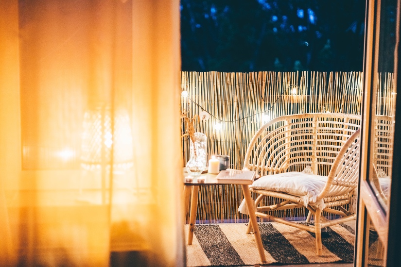 Balkon mit Rattanmöbeln und Beleuchtung 