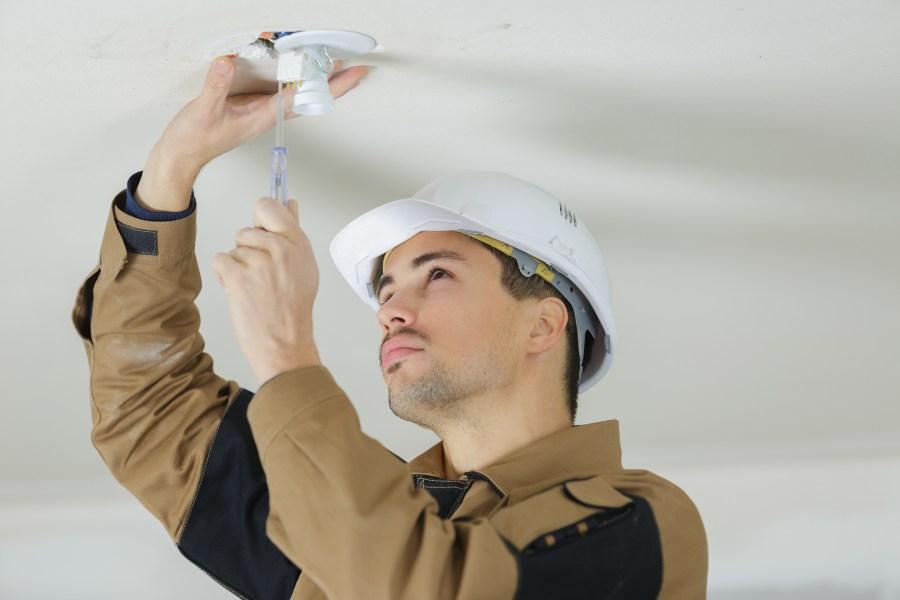 Jemand schließt Lampe an der Decke an Lampe anschließen DIY