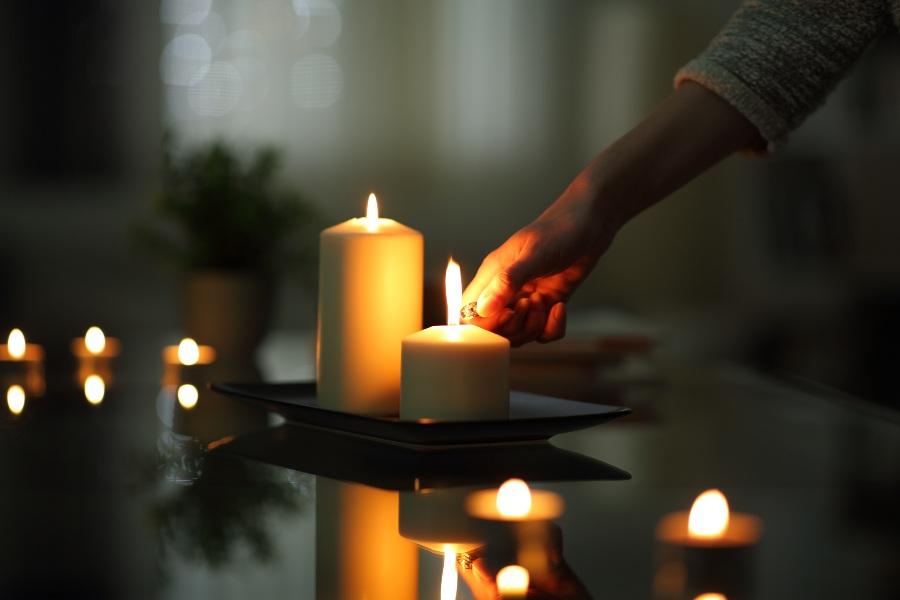 Jemand zündet eine Kerze an - Kerzen flackern, Lichtflimmern ist ein anderes Phänomen