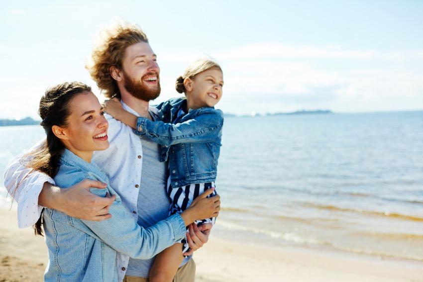 Ehepaar mit Kind am Strand in der Sonne - maximales Blaulicht