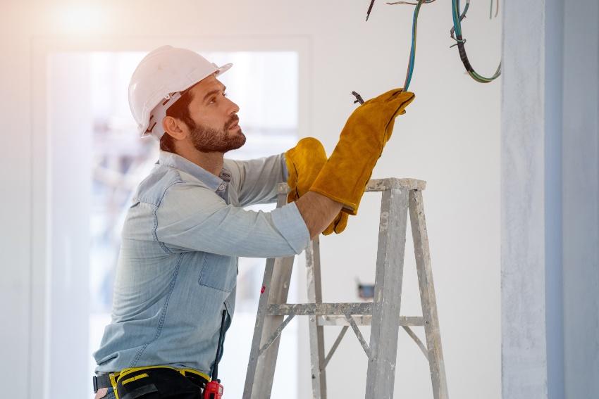  Handwerker installiert Elektrik - Bewegungsmelder mit Taster kombinieren